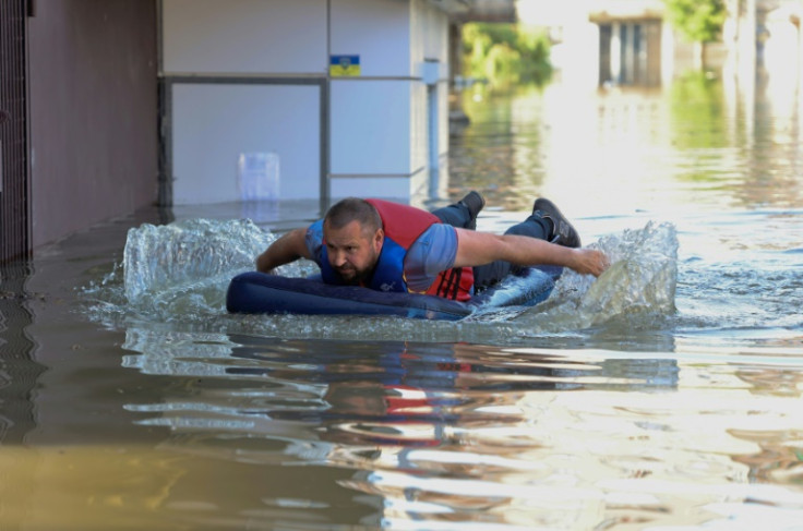 A man escaping the floods in Kherson on an inflatable bed