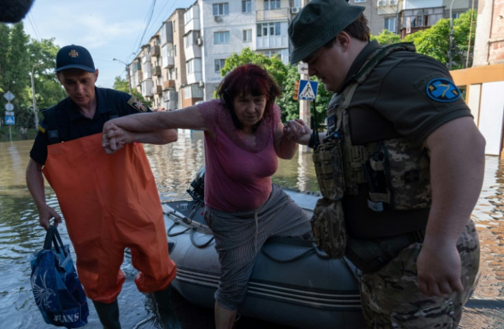 Rescuers help Nataliya Korzh, 68, from a boat in the flooded Ukrainian city of Kherson