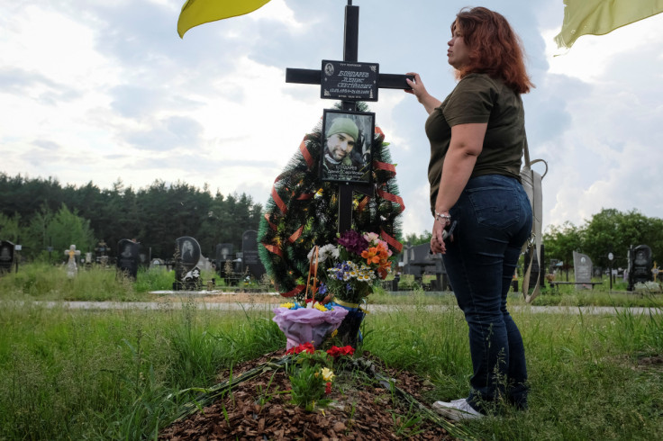 Tetiana Vatsenko-Bondareva reacts as she visits the grave of her husband Denys Bondarev at a cemetery in Poltava