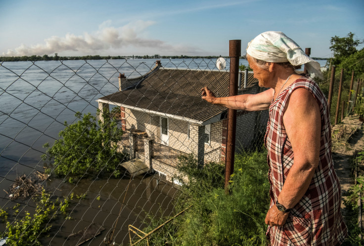 A local resident looks at the Dnipro River which flooded after the Nova Kakhovka dam breached, in Kherson