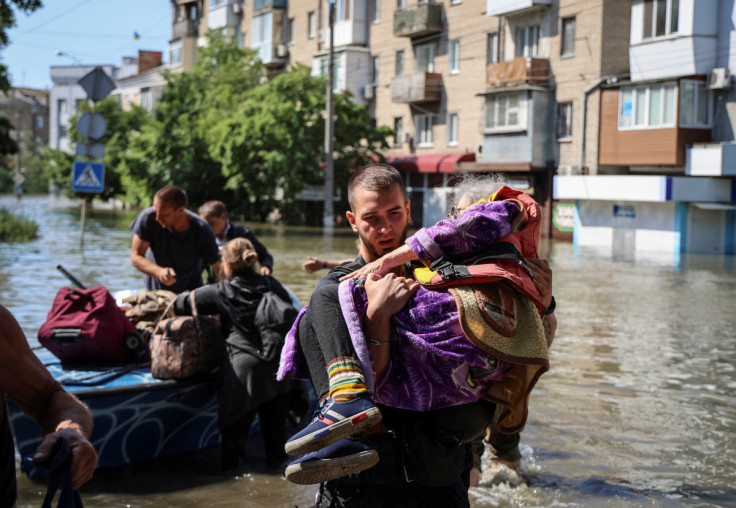 Police evacuate local residents from a flooded area after the Nova Kakhovka dam breached, in Kherson