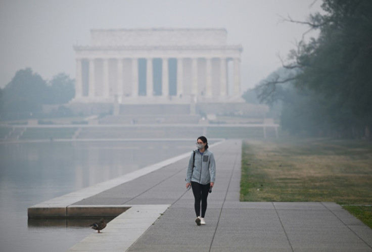 A person walks near the Lincoln Memorial under a blanket of haze in Washington, DC, on June 8, 2023