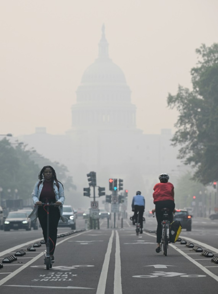 People commute under a blanket of haze partially obscuring the US Capitol in Washington