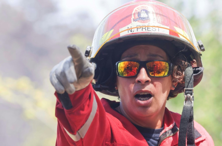 In this May 30 image courtesy of the Nova Scotia government in Canada, Halifax Regional Fire and Emergency Station 54 Captain Natasha Prest directs firefighters working to put out wildfires in the Tantallon area of Nova Scotia