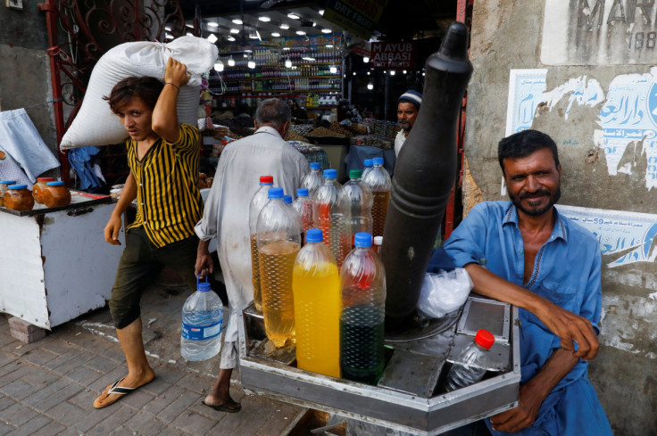 Vendor with his handmade oil extractor wait for customers while selling oil at the entrance of a market in Karachi