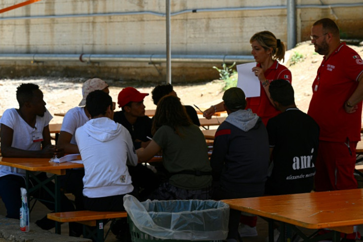 A volunteer of the Italian Red Cross gives an Italian lesson to young migrants on June 7, 2023 at the migrant hotspot on the island of Lampedusa