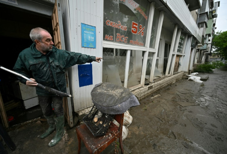 Oleksiy Gesin, 60, clears debris in his flooded Kherson grocery store