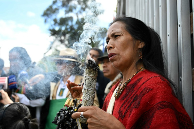 An Indigenous woman who participated in the search for the four missing children performs a ritual outside the Military Hospital in Bogota where they are being treated
