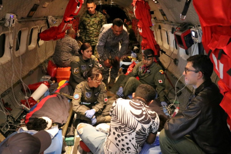 This handout picture taken on June 9, 2023 released by the Colombian Air Force shows members of the Colombian Army checking one of the four Indigenous children who were found alive after being lost for 40 days in the Colombian Amazon