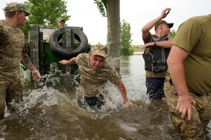 Rescuers push a boat during an evacuation of a flooded area in Afanasiyivka