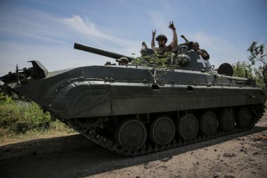 Ukrainian service members ride a BMP-1 infantry fighting vehicle near the front line in the newly liberated village Neskuchne