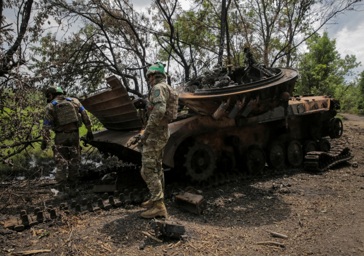 Ukrainian service members check a destroyed Russian a BMP-2 infantry fighting vehicle in the newly liberated village Storozheve