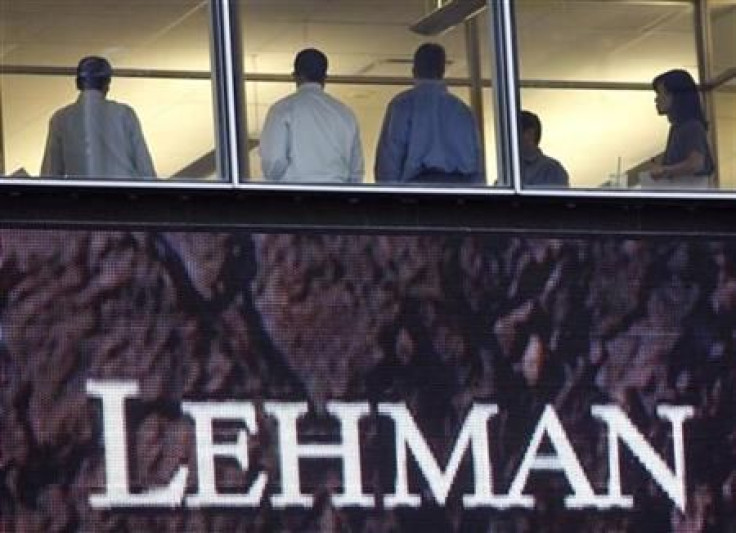 People stand next to windows, above animated sign, at Lehman Brothers headquarters in New York