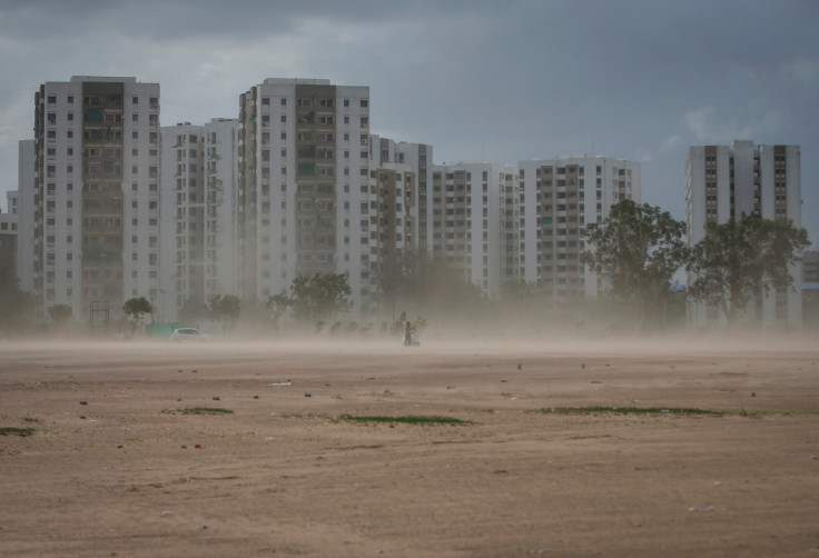 A couple rides a scooter amid dust due to strong wind, before the arrival of cyclonic storm Biparjoy, in Ahmedabad