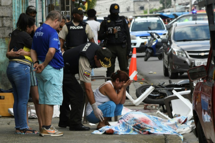 A woman cries over a dead body along a Guayaquil street on June 4, 2023