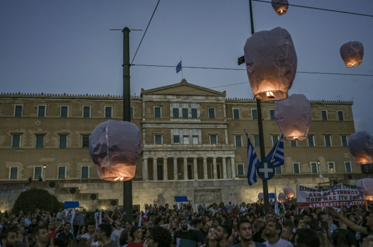 Protesters release hot air balloons in front of the Greek parliament as a tribute to the victims of the disaster