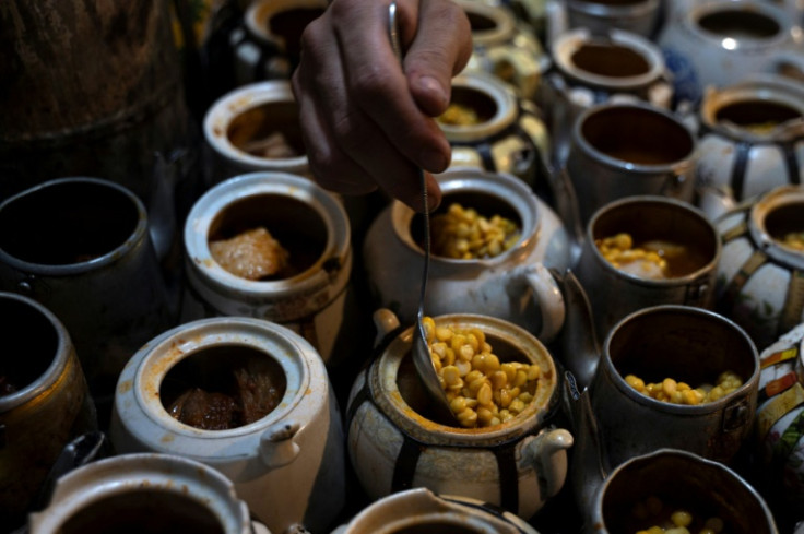 Once the fat has rendered, lentils and a sauce of secret spices are added to each teapot