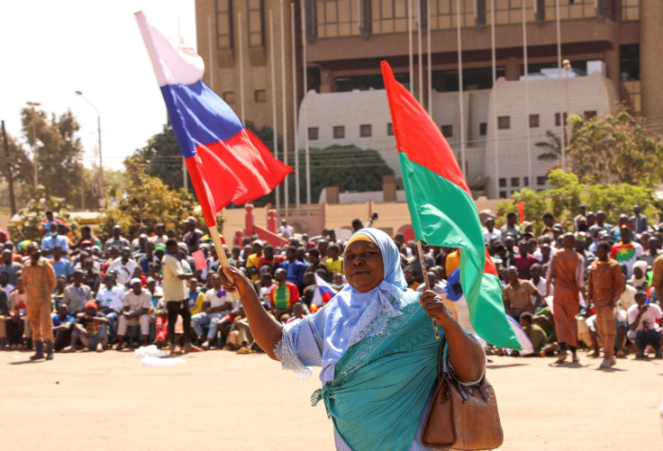 A woman holds her national flag Russian's as people gather to show their support to the Junta leader Ibrahim Traore and demand the departure of the French ambassador in Ouagadougou