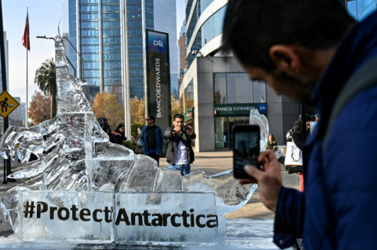 Passers-by take photos of an ice sculpture representing a krill in Santiago on June 19, 2023 as the Commission for the Conservation of Antarctic Marine Living Resources met to discuss three new proposed marine protected areas