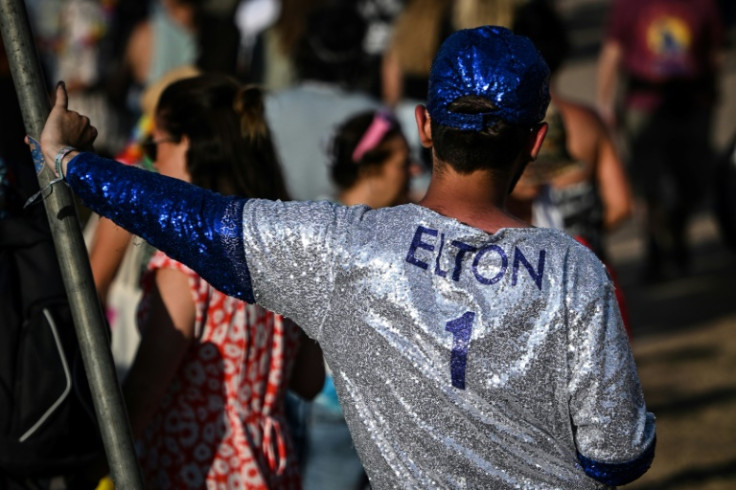 A festival goer wearing a glittering outfit reading "Elton 1" on day one day of the Glastonbury festival