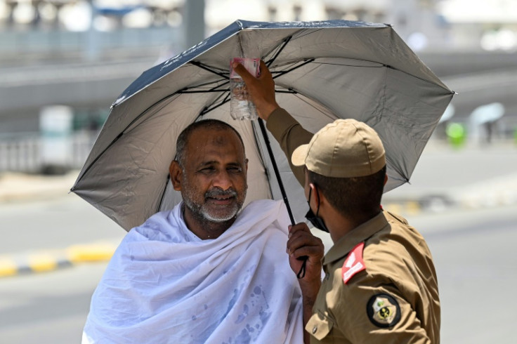 A security official sprays water on a Muslim pilgrim as he arrives in Mina, near Mecca