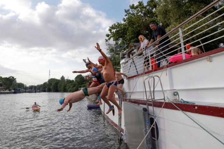 Swimmers leap into the Seine at the Ile Saint-Denis in July