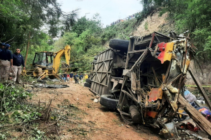 The wreckage of a bus lies on its side after plummeting into a ravine in the southern Mexican state of Oaxaca