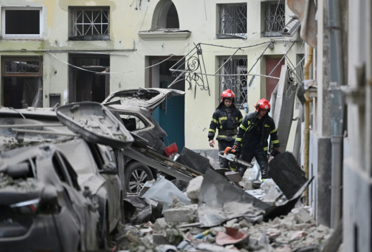Rescuers on the scene of a rare missile strike in the western Ukrainian city of Lviv, after which the country's leader vowed to respond