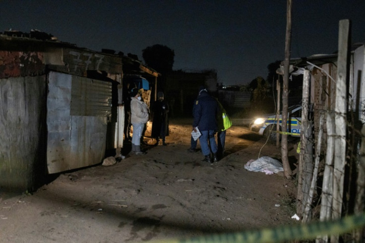 Gas disaster: Police standing near a body covered with a blanket in the Angelo slum