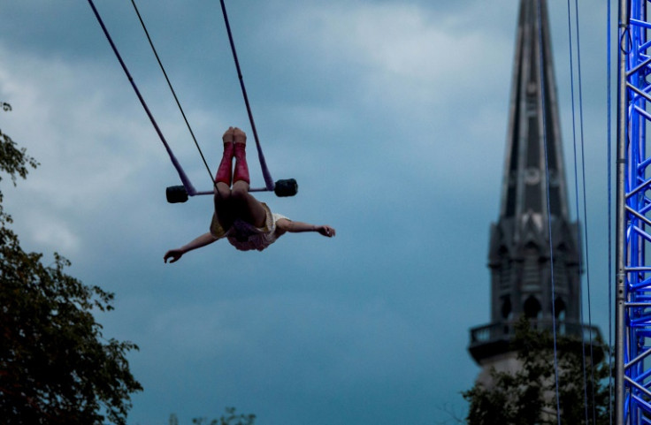 A trapeze artist performs on Montreal's Saint-Denis Street