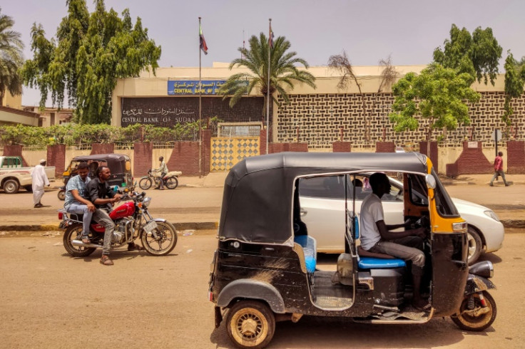 Sudanese drive past a branch of the Central Bank of Sudan in the country's eastern city of Gedaref