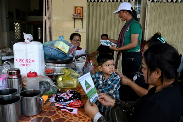 A member of Cambodia's Grassroots Democratic Party distributes campaign leaflets