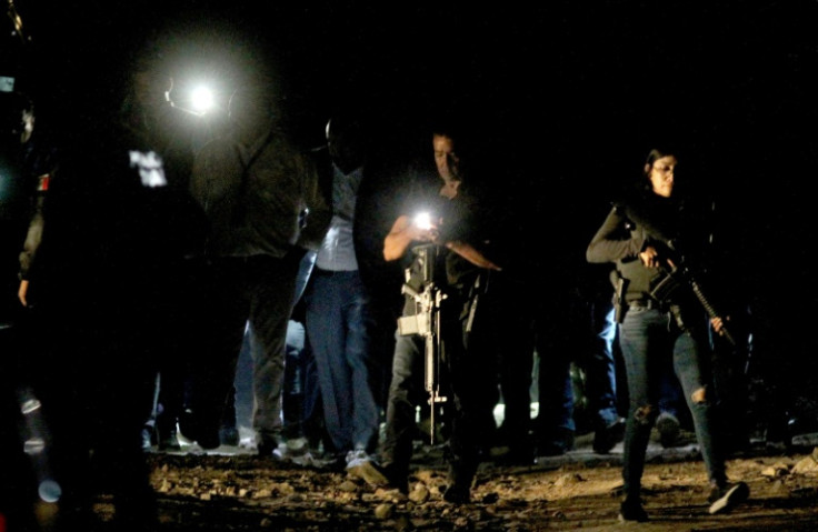 Mexican prosecutors and forensic experts collect evidence after an explosives attack on police in the western state of Jalisco