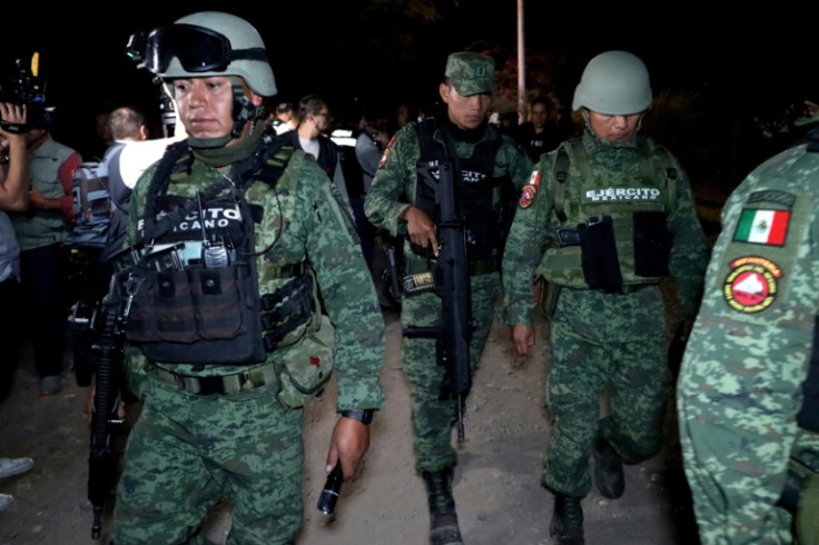 Mexican soldiers are seen at the site of an explosives attack on a police patrol in the western state of Jalisco