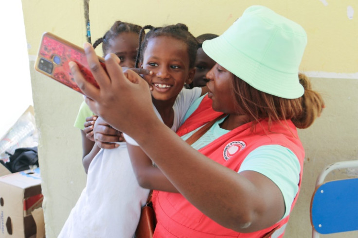 A Tunisian Red Crescent worker snaps a selfie with young migrants who fled violence in Sfax