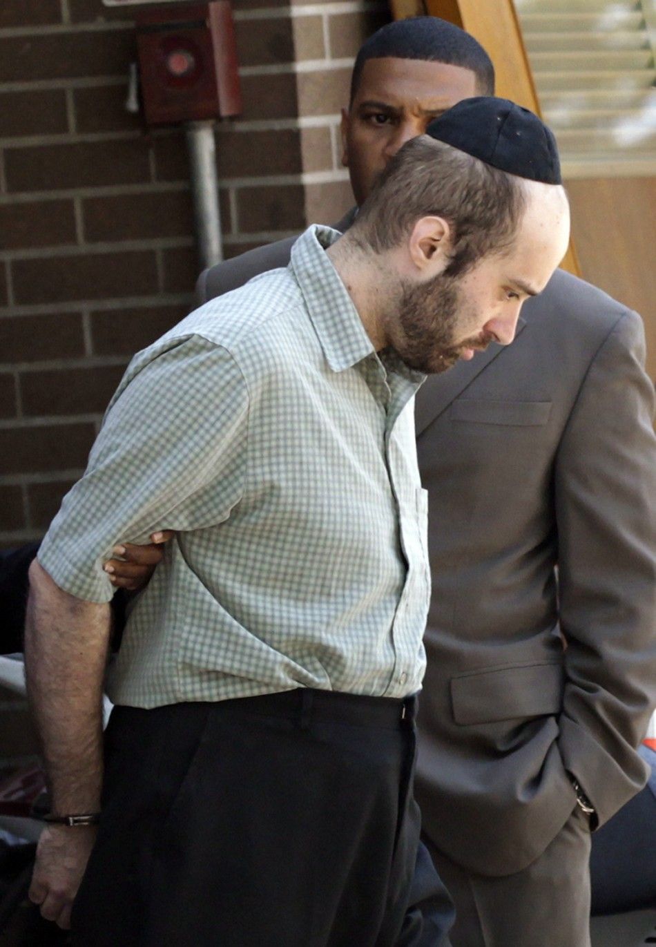 Levi Aron is escorted out of a New York Police Department precinct in Brooklyn