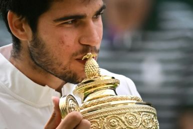 Champion: Carlos Alcaraz kisses the winner's trophy after beating Novak Djokovic