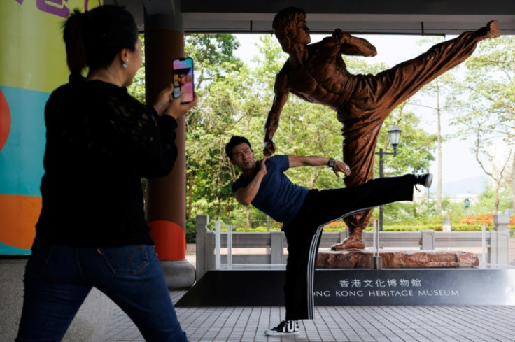Visitors take pictures with a statue of Bruce Lee outside the Hong Kong Heritage Museum