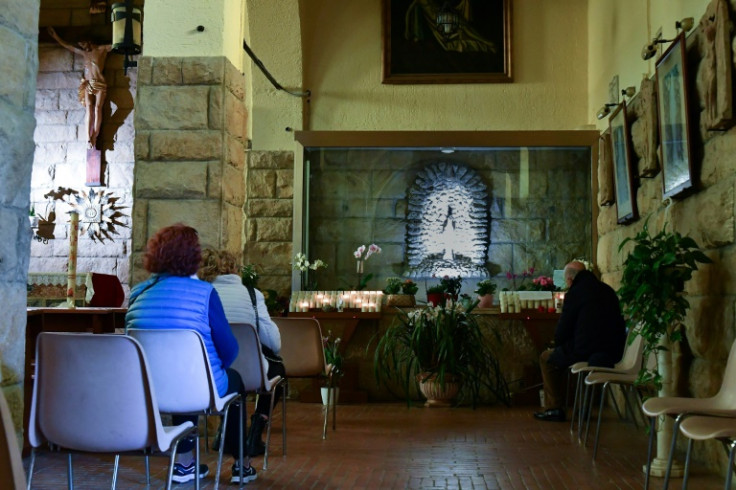 Worshippers gather in front of a statue of the Virgin Mary which is said to bleed in a church at Civitavecchia near Rome
