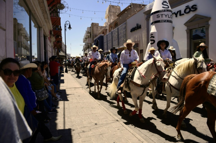 Mexicans take part in a horseback parade marking the centenary of the murder of Mexican outlaw turned revolutionary Francisco "Pancho" Villa