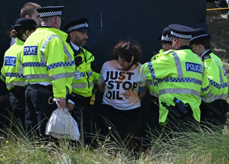 Police detain a climate activist from Just Stop Oil at the British Open