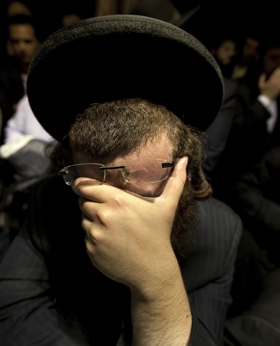 A man weeps while listening to the funeral of Leiby Kletzky in the Brooklyn borough of New York