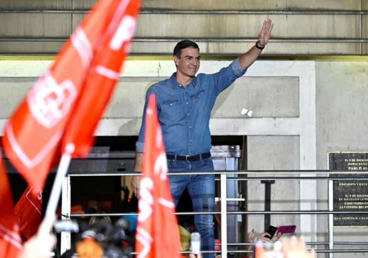 Spanish Prime Minister Pedro Sanchez greets supporters gathered outside of his Socialist party headquarters in Madrid on election night