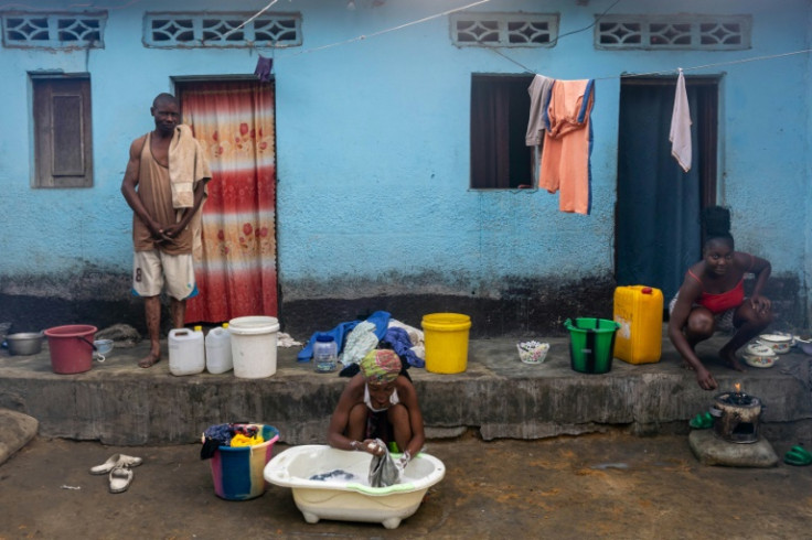 A woman washes clothes with water drawn from a well in Selembao
