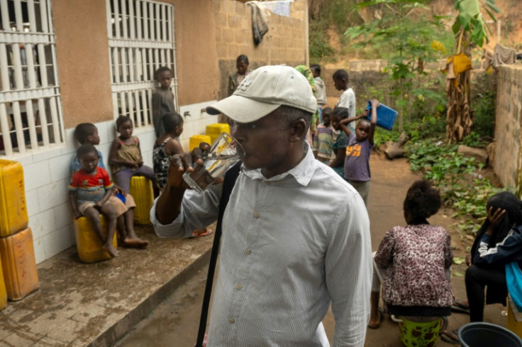 Gautier Dianzitu Kulu-Kimbembe drinks water drawn from a communal well in Selembao, a poor neighbourhood with very little water or electricity