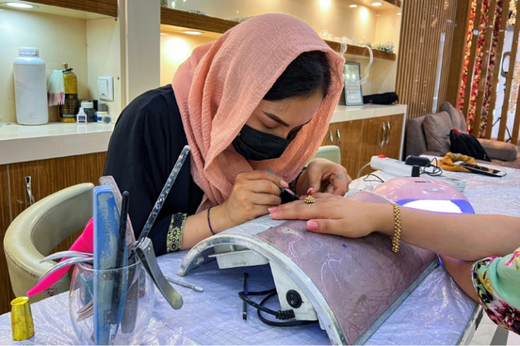 An Afghan beautician gives a customer a manicure at a salon in the capital