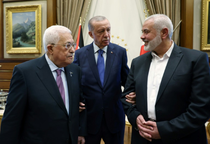This handout photograph taken and released by the Turkish Presidency Press Office on July 26, 2023, shows Turkish President Recep Tayyip Erdogan (C) meeting with Palestinian President Mahmoud Abbas (L) and the leader of the Palestinian Hamas movement Isma