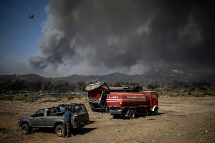 Local residents watch the wildfires from afar near the village of Vati in Rhodes