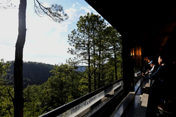 Passengers enjoy the view through the open windows of the Chepe Express's bar