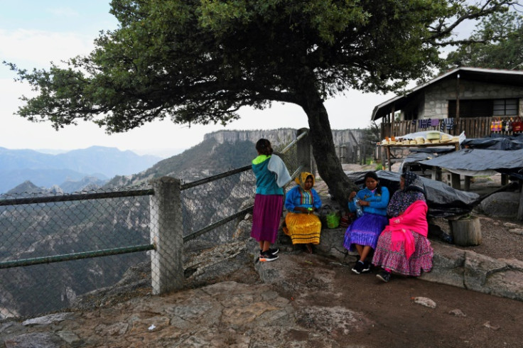 Women selling handicrafts wait for tourists outside the Divisadero train station on Mexico's El Chepe railway